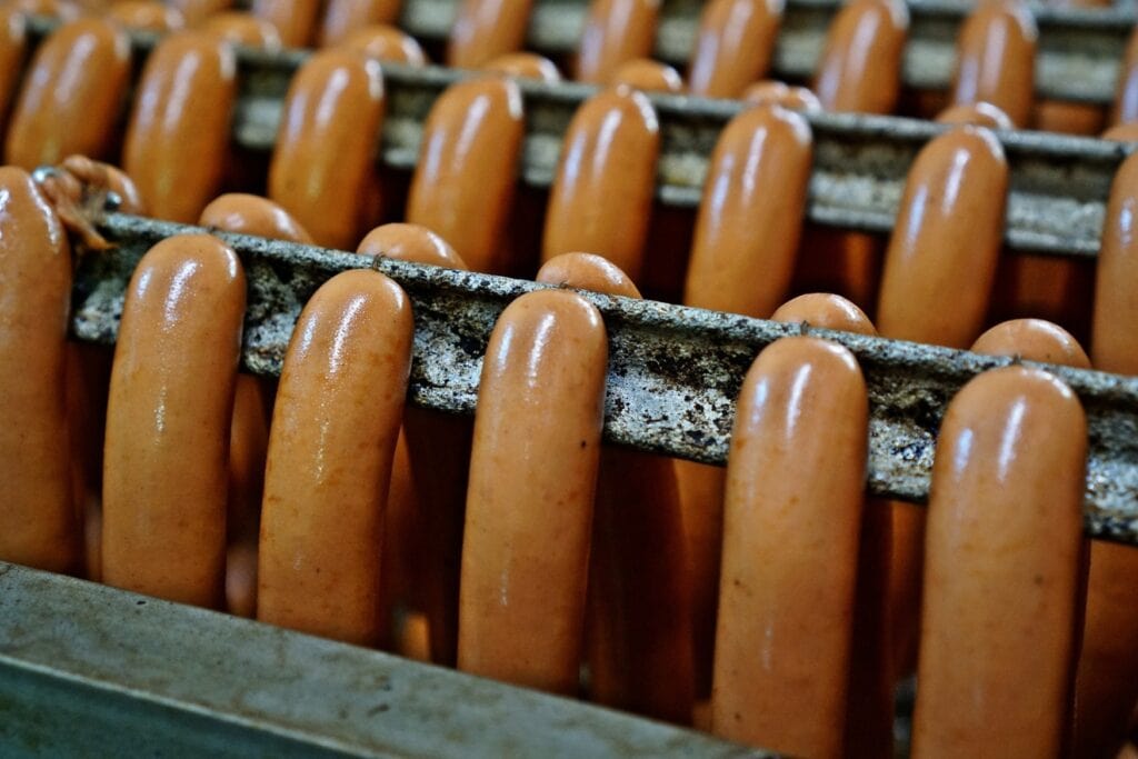 Mehrere Bockwurstpaare hängen zum Brühen auf einer Stange - eine der beliebtesten Wurstsorten in Deutschland