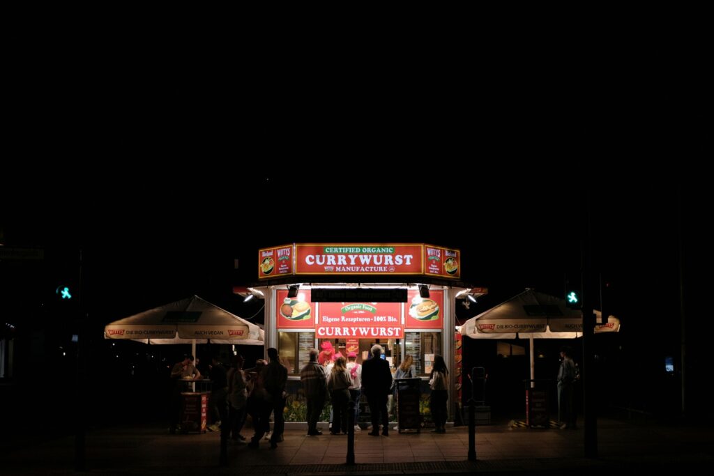 A well-attended currywurst stand at night