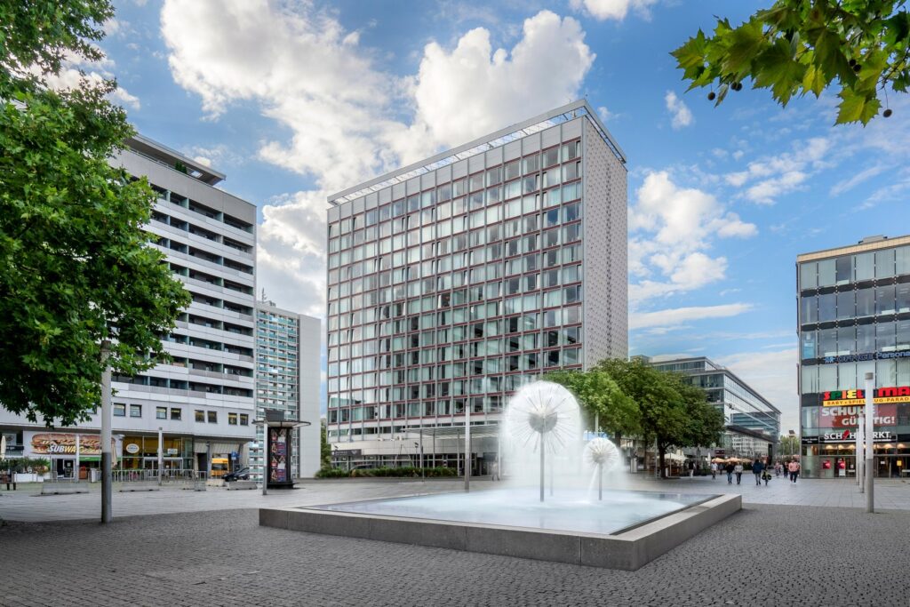 The high-rise hotel Occidental Dresden Newa from the outside, with a fountain in front of it