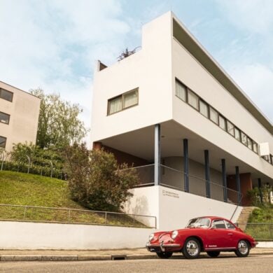 Das Weissenhof-Museum in Stuttgart, ein kantiges, weißes Gebäude. Im Vordergrund ein roter Oldtimer-Porsche
