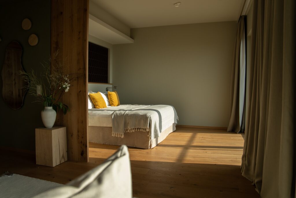 In a room in the forest. Far away in the Rheingau, the sun shines through a window onto the large double bed.