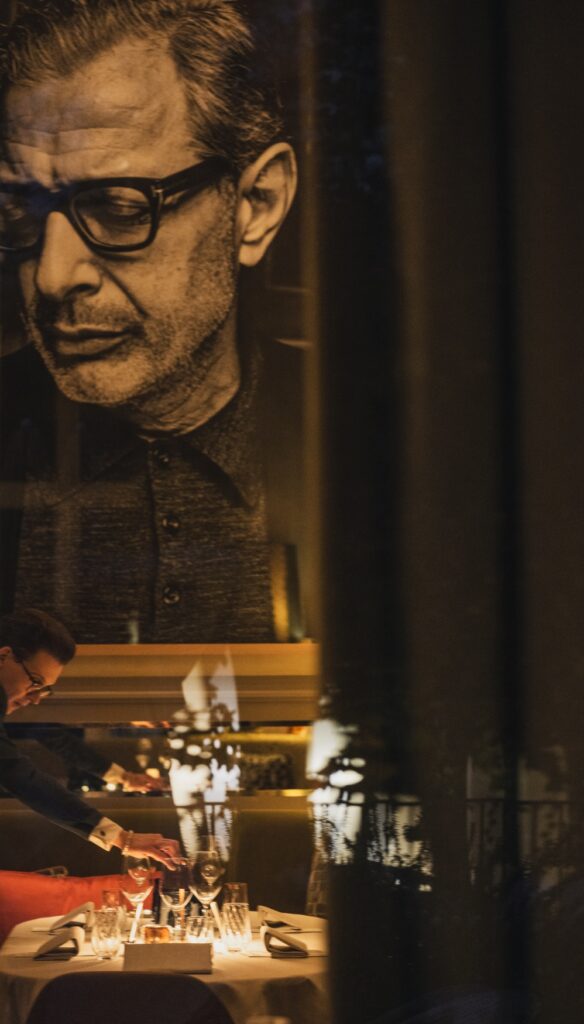 Ein gedeckter Tisch im Restaurant Louis in Saarlouis im Kerzenschein. Im Hintergrund ein großes Bild des Schauspielers Jeff Goldblum