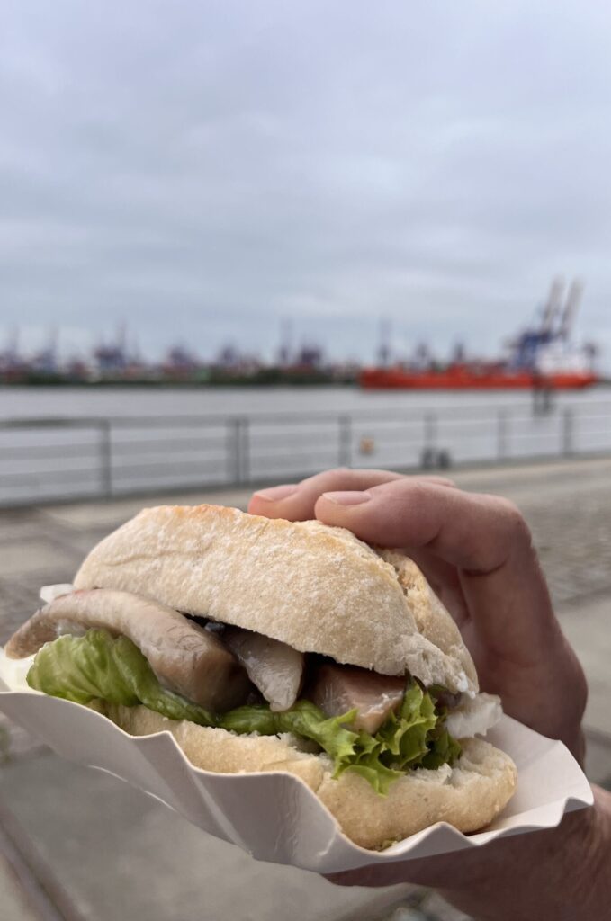 A woman in Hamburg holds a fish roll in her hand.