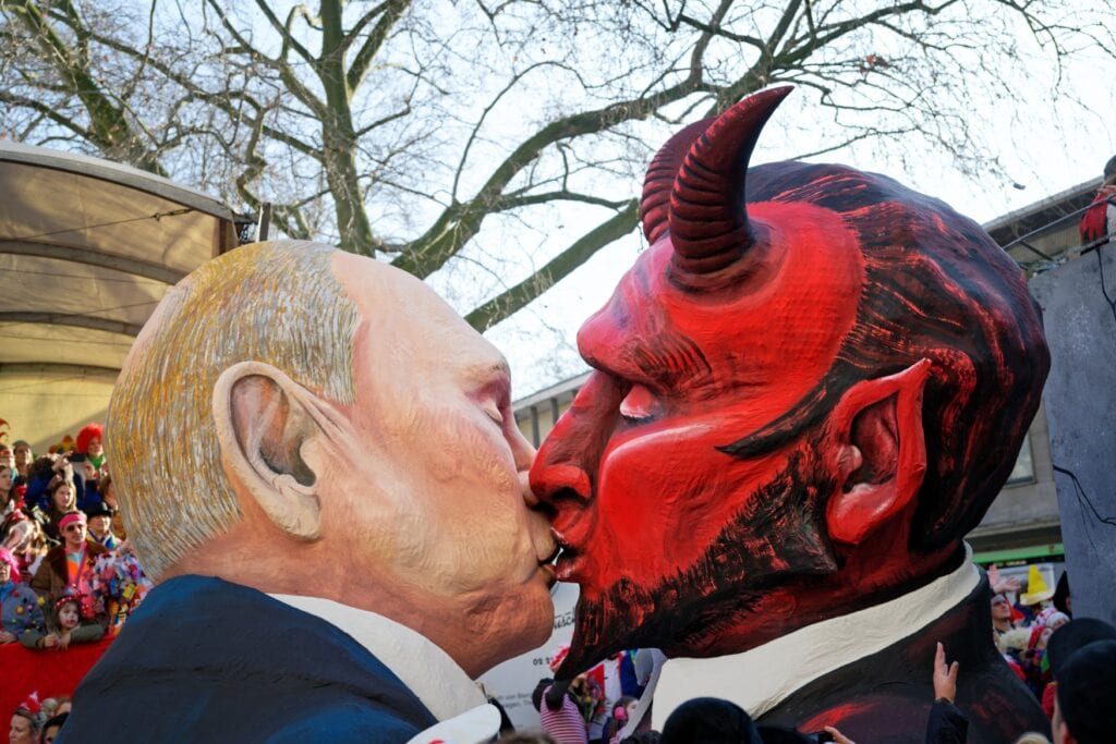 Ein Wagen beim Kölner Rosenmontagsumzug zeigt einen Kuss zwischen Wladimir Putin und dem Teufel.