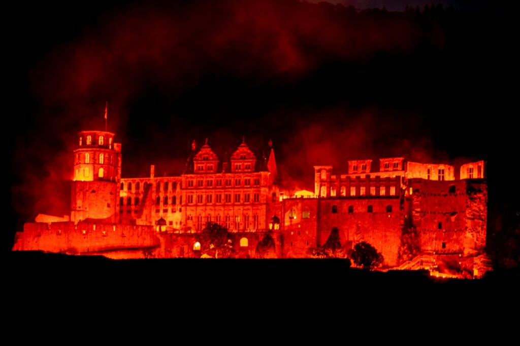 Das Heidelberger Schloss, während der Schlossbeleuchtung in einem kräfigen Rot angestrahlt.