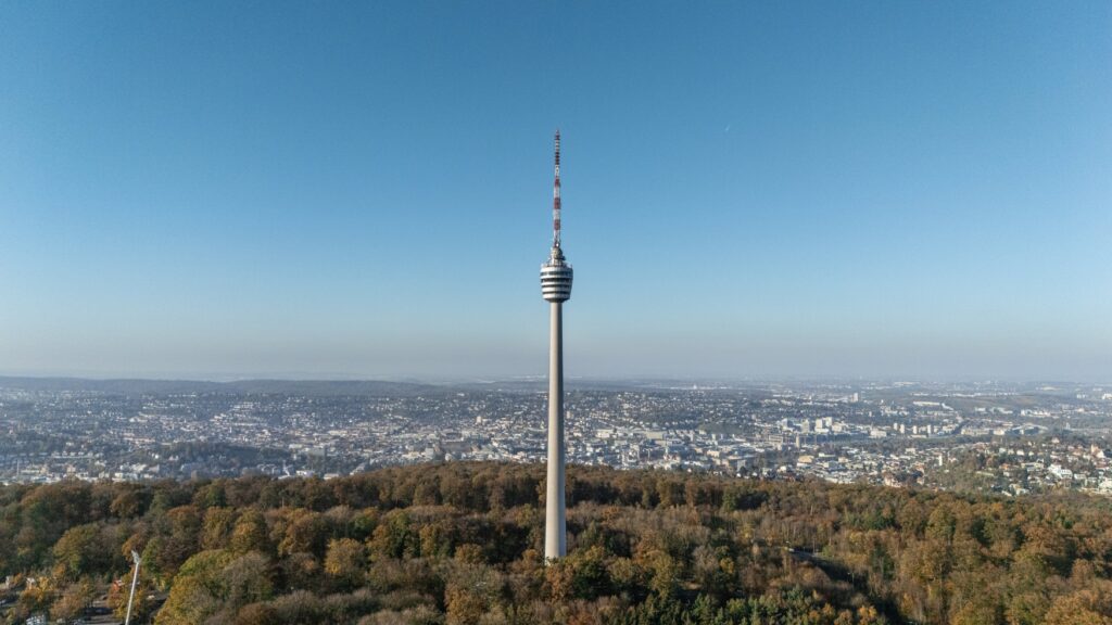 Stuttgart's television tower rises above the city from a wooded area.