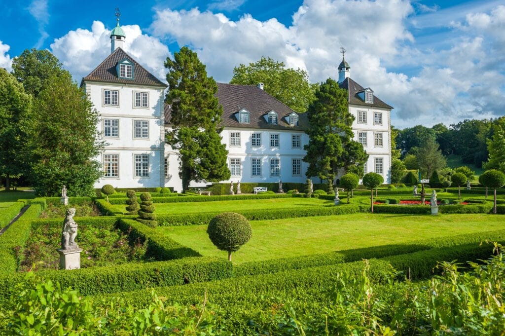 Haupthaus von Gut Panker, mit grünem Garten vor dem Herrenhaus. Ein beliebtes Ausflugsziel von Kiel aus