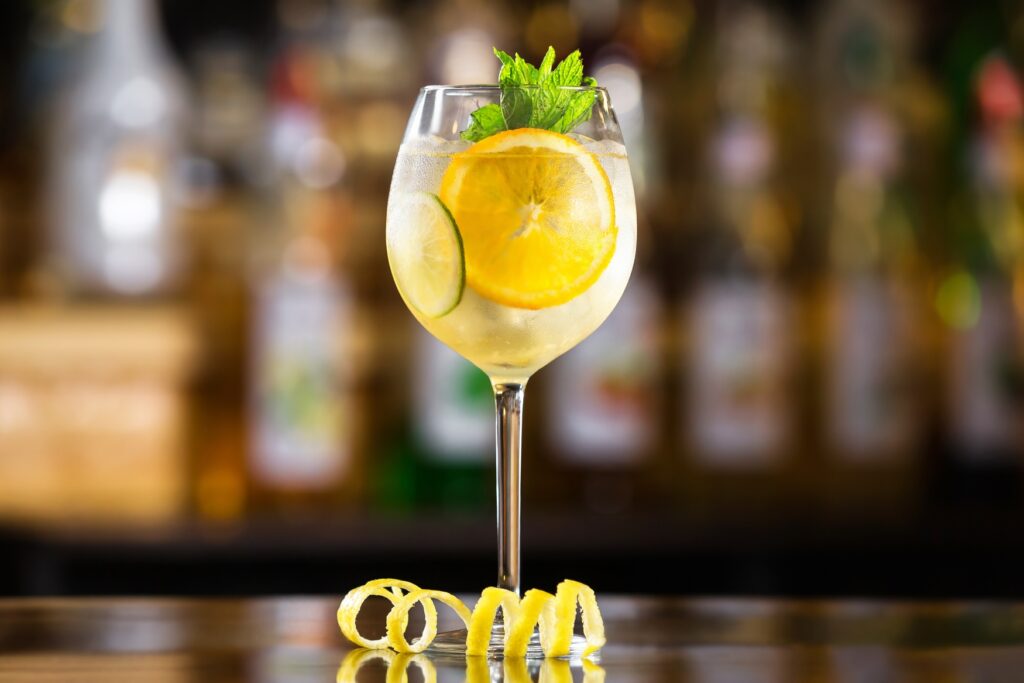 A wine glass with sparkling wine and lemonade, garnished with lemon slices