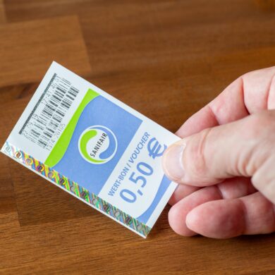 A hand holding a Sanifair receipt