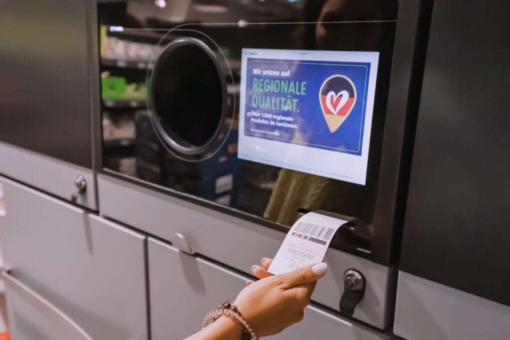 A woman pulling the deposit receipt from a "Pfand" machine in Germany