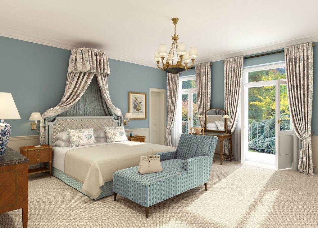 A newly designed room at the Brenners Park-Hotel & Spa, with light blue walls, a canopy over the bed, and a light blue chaise lounge.