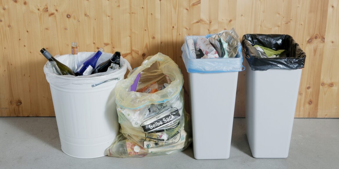 Four different trash cans in a row