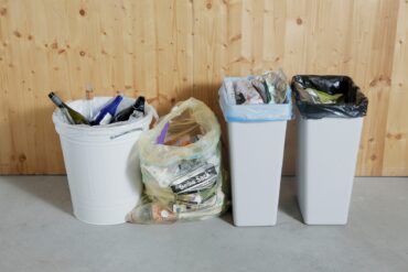 Four different trash cans in a row