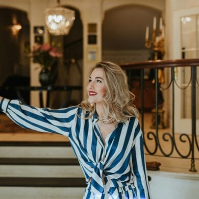 A woman stands in the entrance of a luxury hotel.