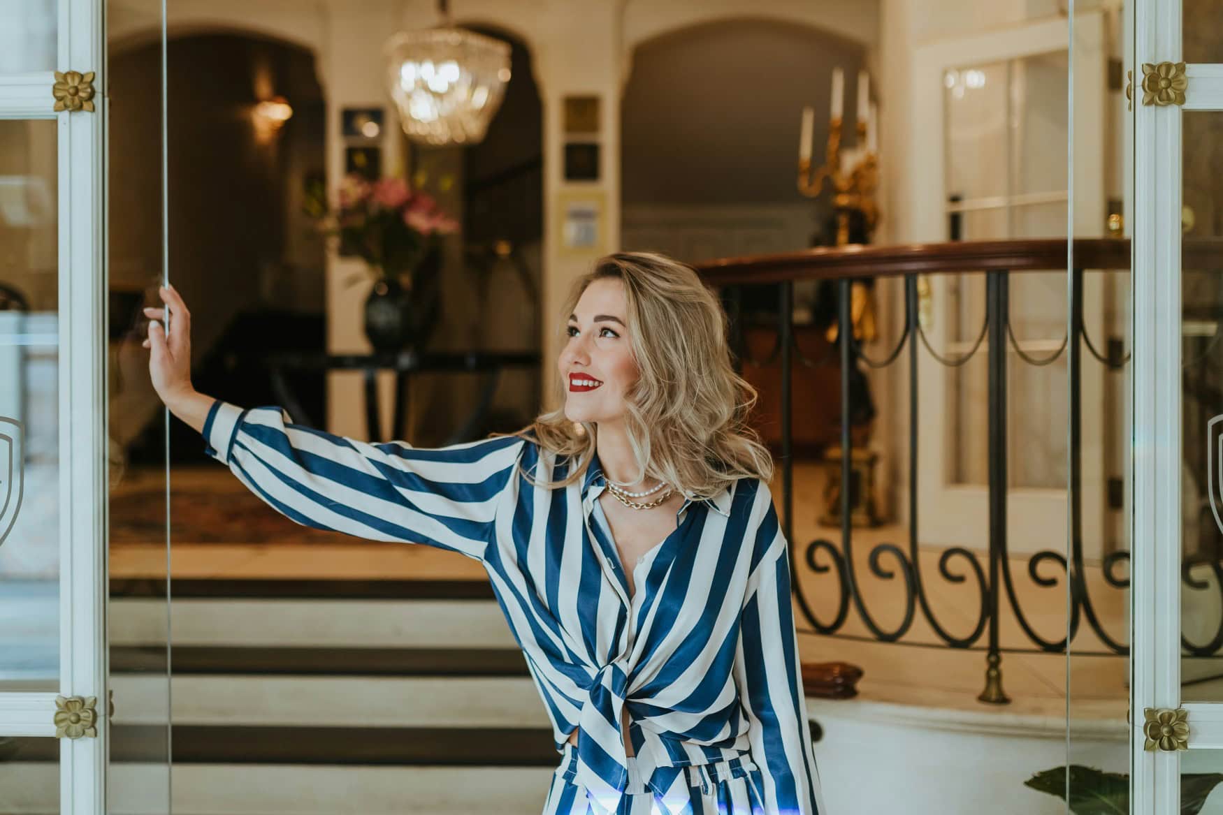 A woman stands in the entrance of a luxury hotel.