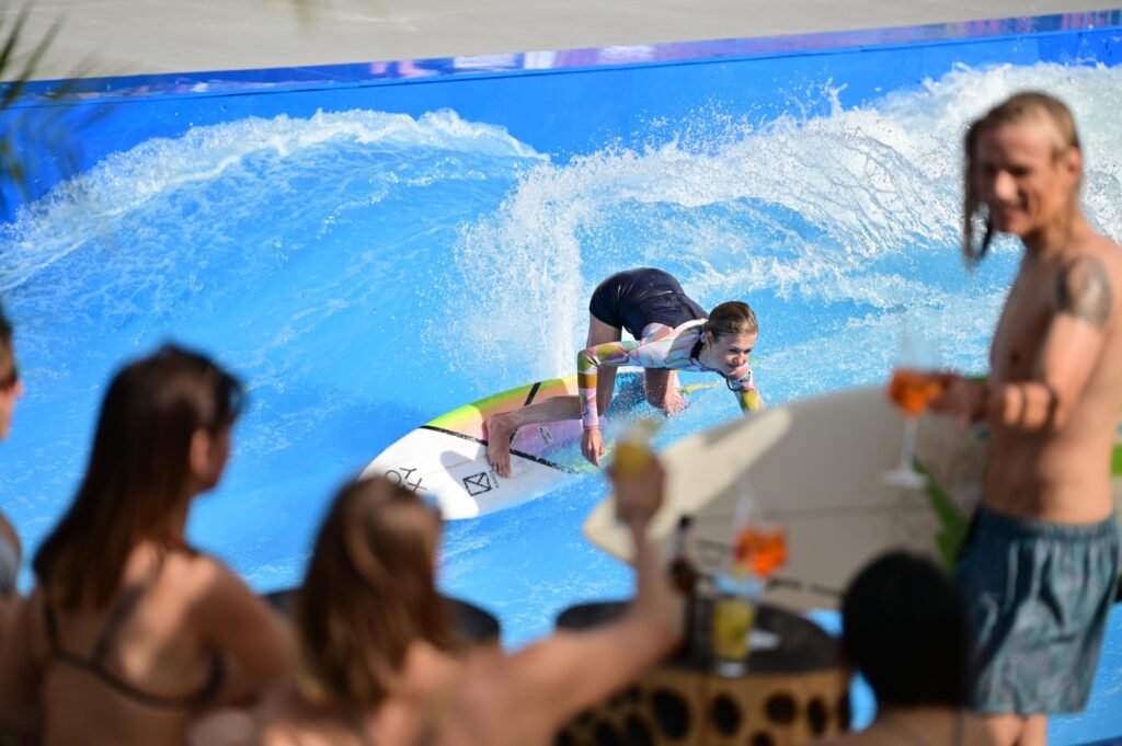 A person surfs on an artificial wave at Citywave Freiburg.