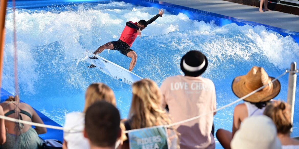 A person surfs on an artificial wave at Citywave Freiburg.