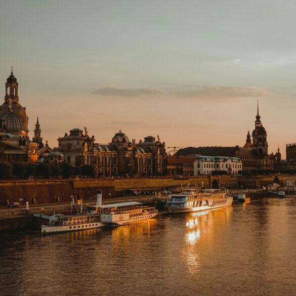 Die Dächer der Dresdner Altstadt, mit Landtag und Frauenkirche, liegen am Elbufer im roten Licht der Abendsonne.
