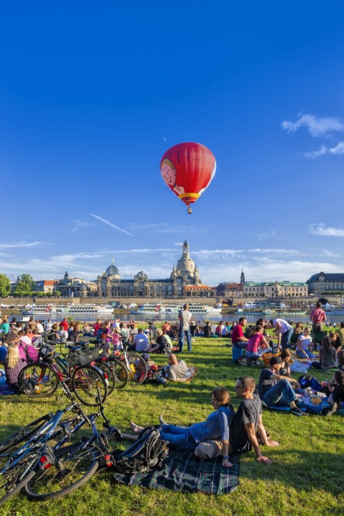 Menschenleben auf den Dresdner Elbwiesen mit Blick auf die Frauenkirche.