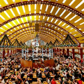 Panoramic view of a festival tent at Oktoberfest in Munich. Every table is full of people.
