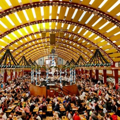 Panoramic view of a festival tent at Oktoberfest in Munich. Every table is full of people.