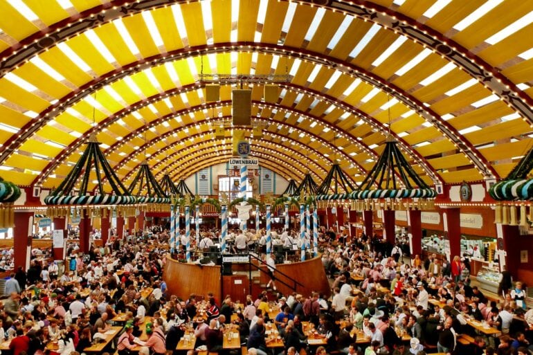 Panoramic view of a festival tent at Oktoberfest in Munich. Every table is full of people.