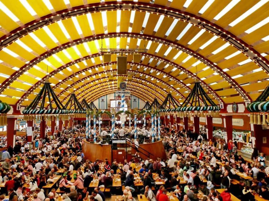 Panoramic view of a festival tent at Oktoberfest in Munich. Every table is full of people.