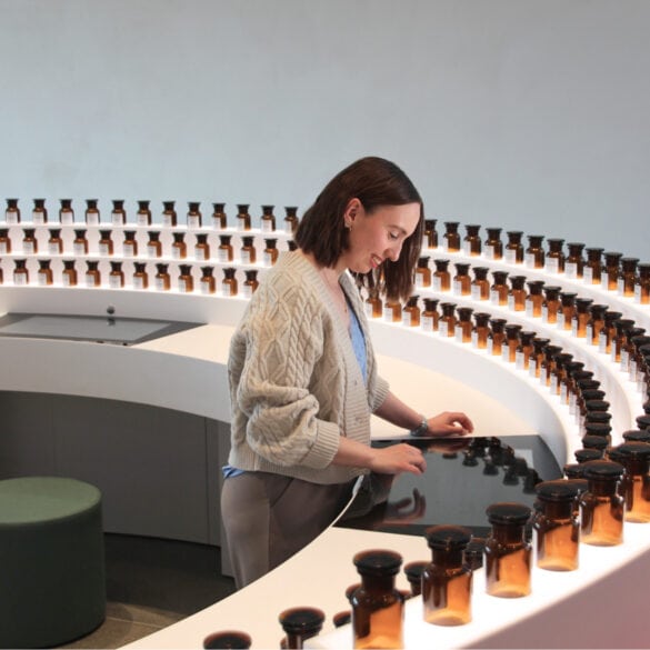 A young woman is operating a touchscreen built into a semicircular sideboard. Along the outer edge of the sideboard are