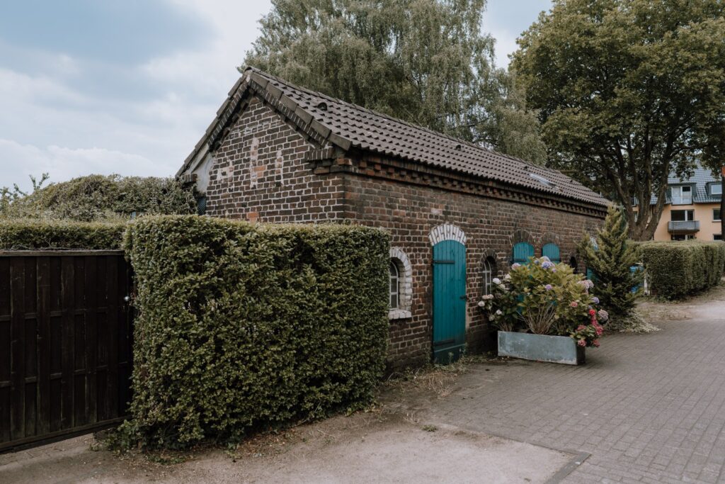 A small, single-story brick house stands in a workers' housing estate in Oberhausen.