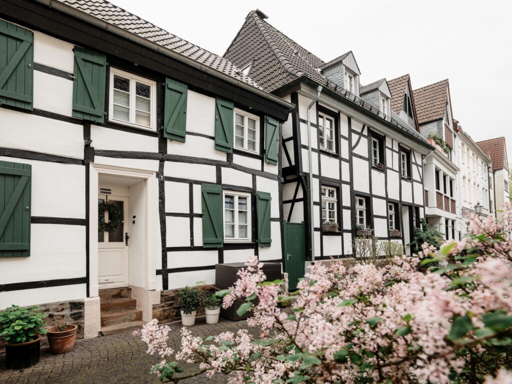 Several small half-timbered houses stand close together along a street.