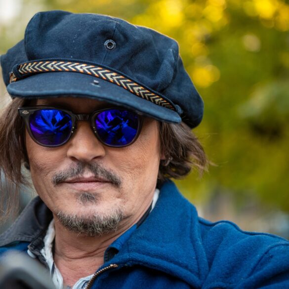 Der Schauspieler Johnny Depp mit einer blauen Mütze, einer blau getönten Sonnenbrille und einer blauen Jacke.