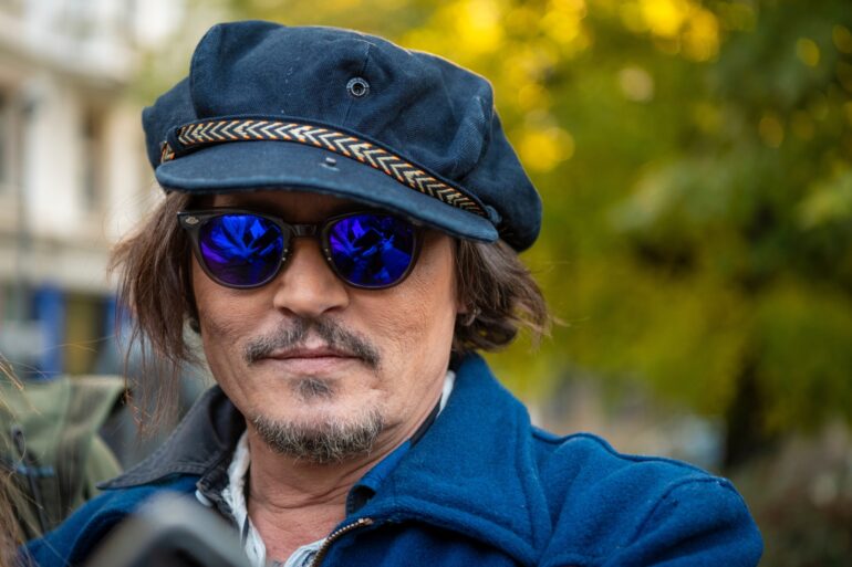 Der Schauspieler Johnny Depp mit einer blauen Mütze, einer blau getönten Sonnenbrille und einer blauen Jacke.