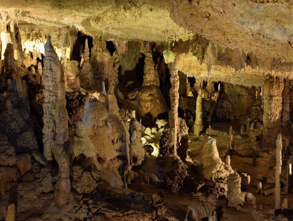 Weitläufige Tropfsteinhöhle mit zahlreichen Stalagmiten und Stalaktiten in der König-Otto-Tropfsteinhöhle in der Oberpfalz bei Velburg, warm beleuchtet.