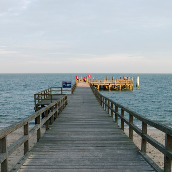 Ein hölzerner Steg auf der Insel Föhr führt auf die Nordsee hinaus.