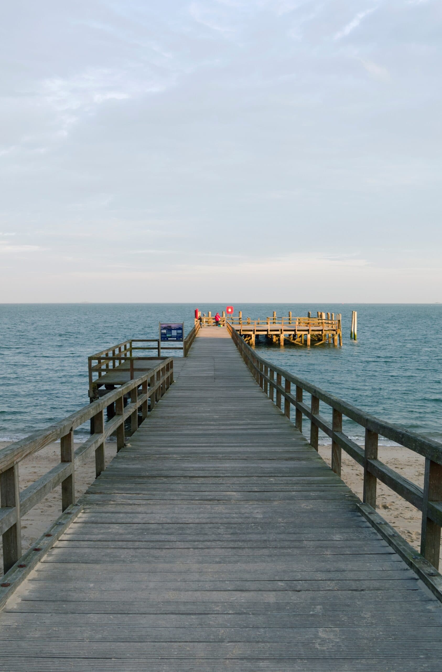 Ein hölzerner Steg auf der Insel Föhr führt auf die Nordsee hinaus.