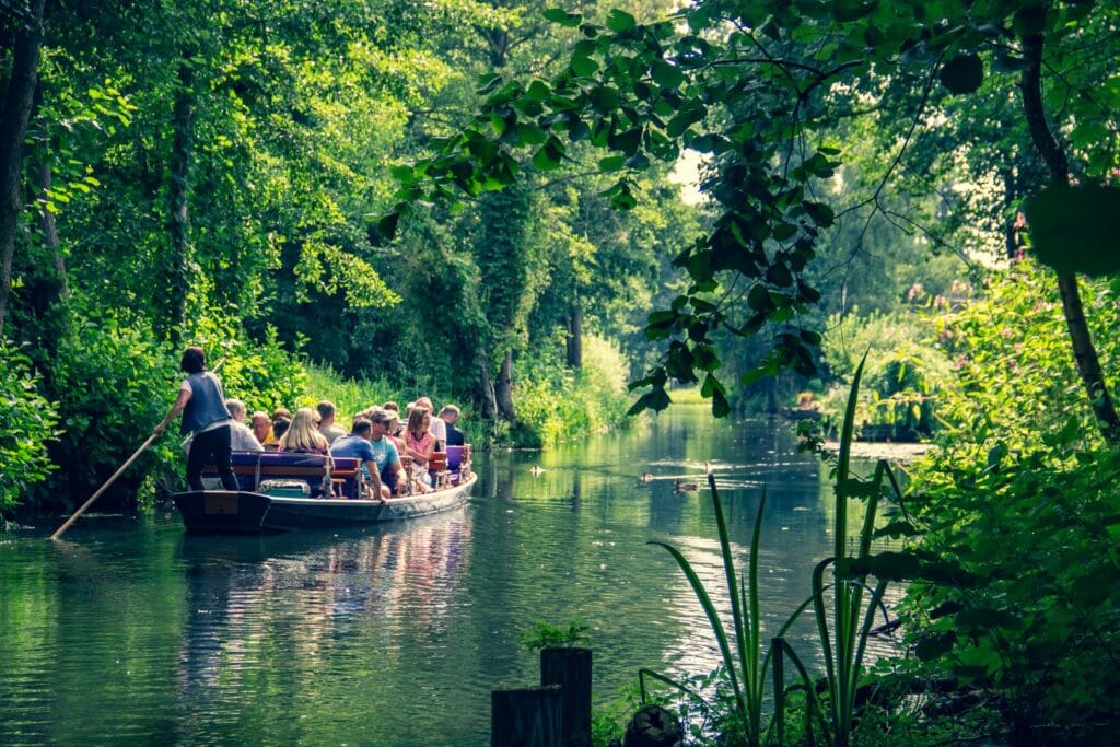A boat full with people running on a river in the german Spreewald region