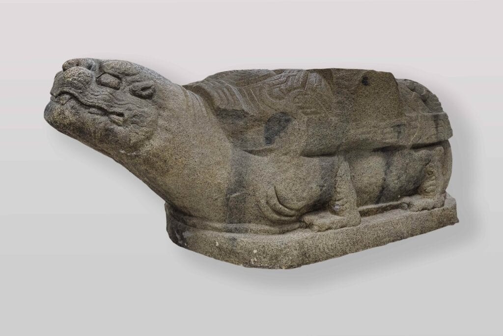 Moderne Kopie einer Schildkrötenstatue aus Karakorum. Das liegende Steintier mit gerecktem Kopf und gemustertem Panzer ruht auf einer flachen Platte. Das Original stammt aus dem 13. Jahrhundert.