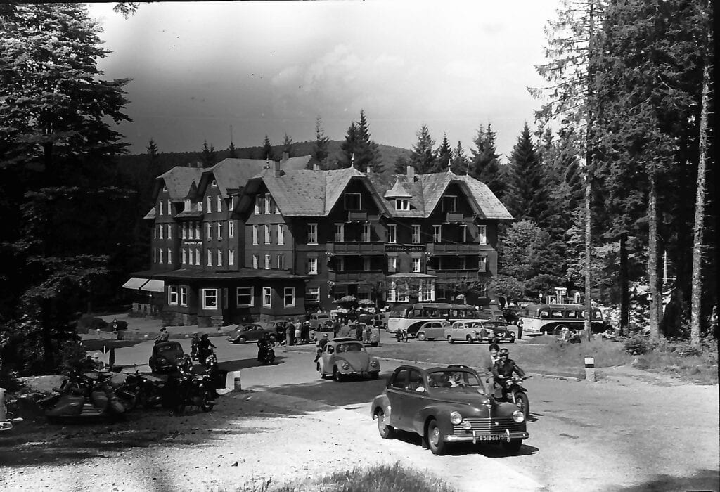 Aufnahme aus einem Schwarz-Weiß-Film; ein hölzernes Kurhaus in für den Schwarzwald typischer Architektur, davor einige Fahrzeuge. Aufgenommen etwa in den 1930ern.