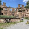 Lost Places in Baden-Württemberg: Ruine des Wasserschlosses Menzingen in Kraichtal mit verwitterten Steinmauern, leeren Fensteröffnungen und einem Fahrrad im Vordergrund.