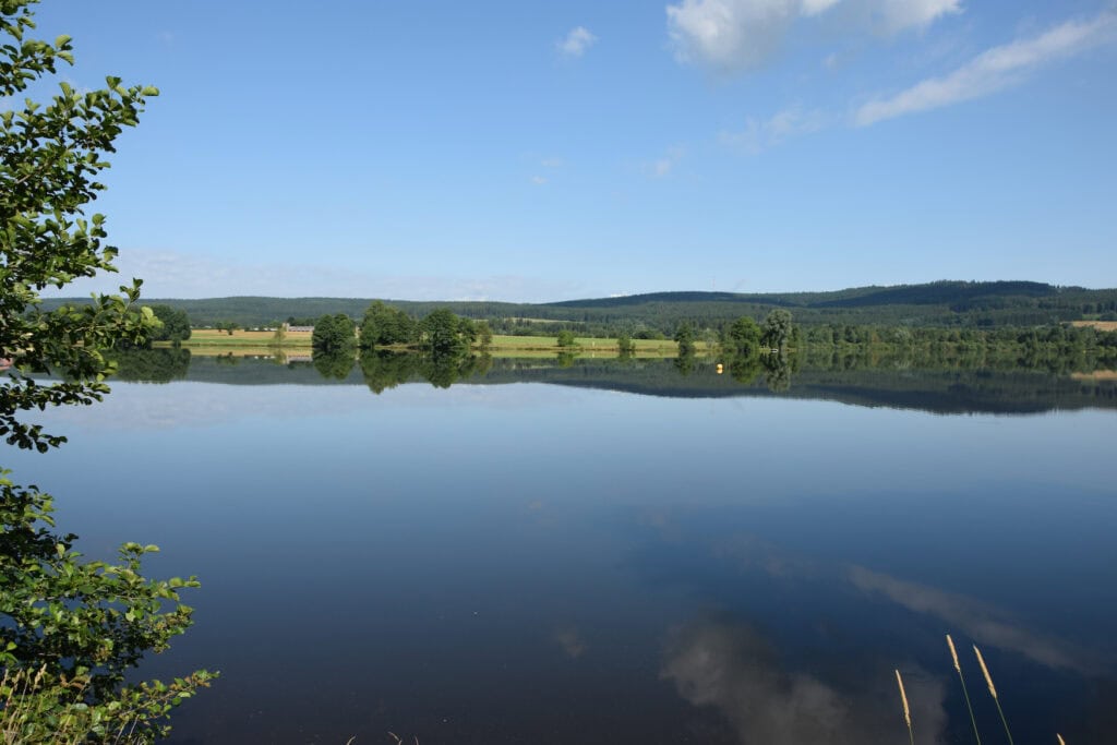 Weißenstädter See im Fichtelgebirge mit bewaldeten Höhenzügen im Hintergrund.